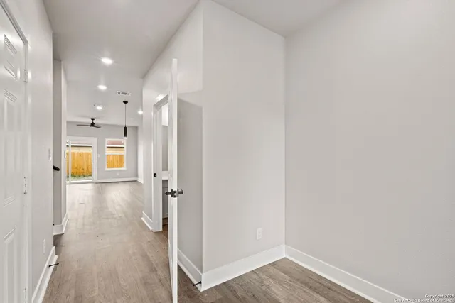 a view of a hallway with wooden floor and windows