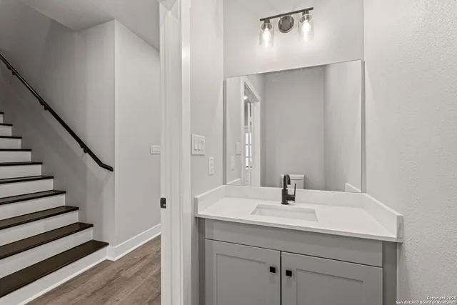 a large kitchen with cabinets wooden floor and stainless steel appliances
