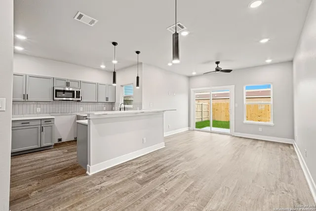a view of an empty room and kitchen view