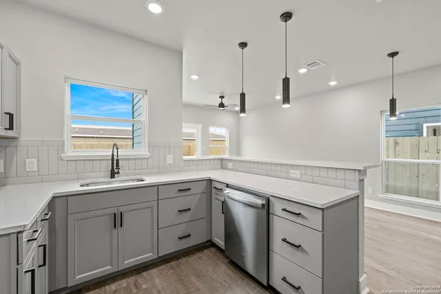 a kitchen with cabinets stainless steel appliances and sink