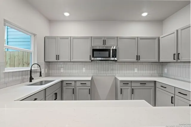 a kitchen with sink cabinets and microwave