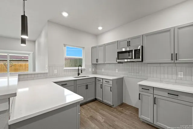 a kitchen with a sink stove and microwave