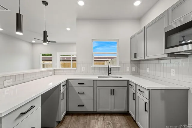 a kitchen with white cabinets and appliances