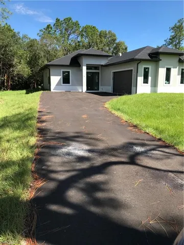 a front view of a house with a garden and yard