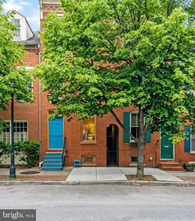a front view of a house with a tree