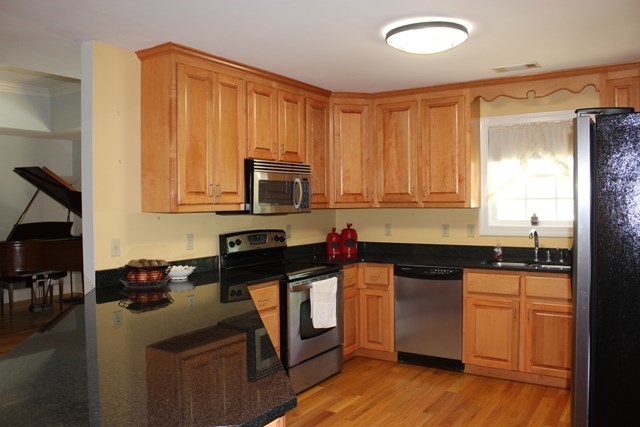 11 Dillard Road Forsyth, GA 31029 - Photo 6 of 14 a kitchen with stainless steel appliances granite countertop a stove a sink dishwasher and a microwave oven with wooden cabinets