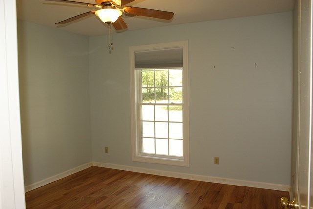 11 Dillard Road Forsyth, GA 31029 - Photo 9 of 14 an empty room with wooden floor fan and windows