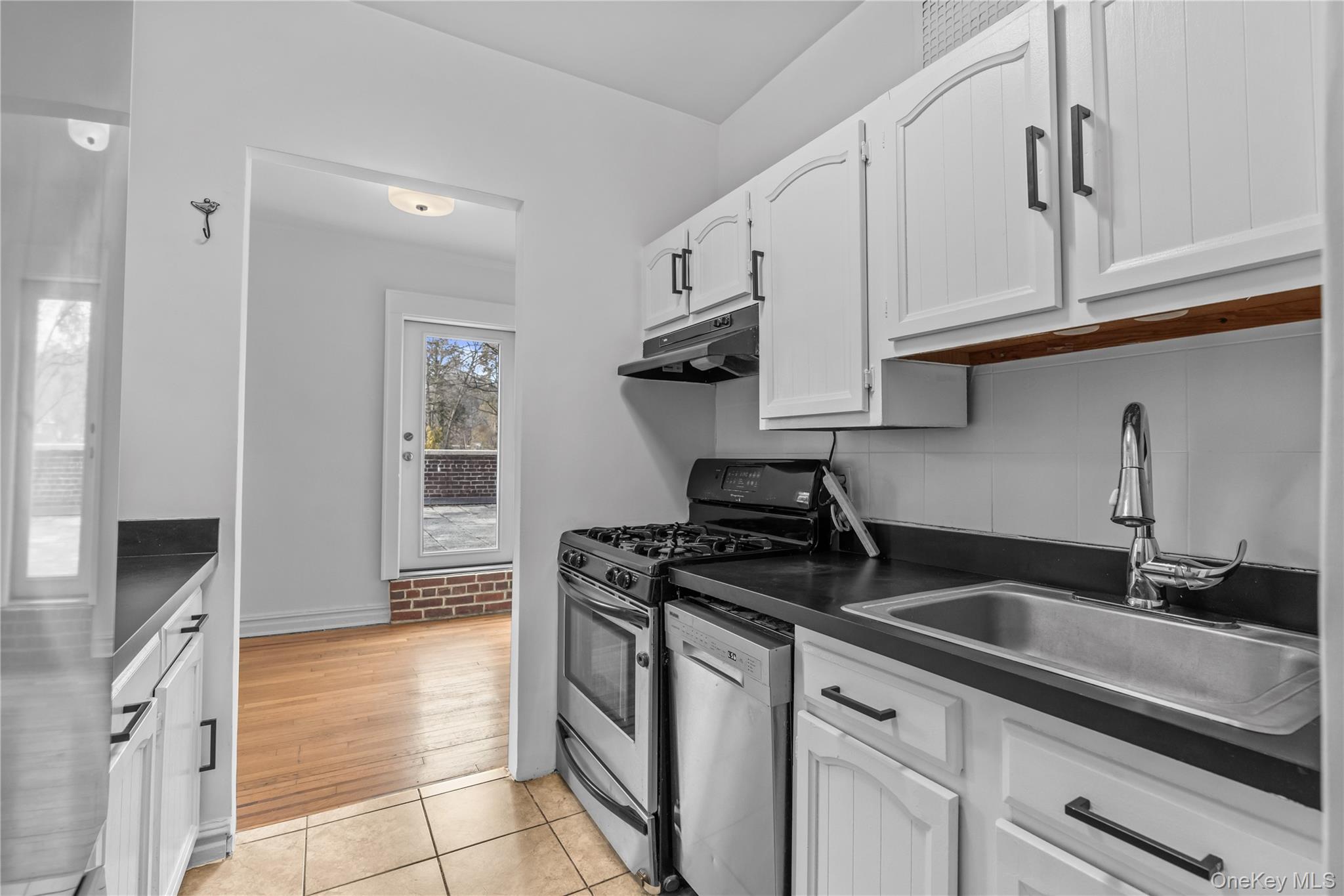 822 Palmer Road, Unit 3B Bronxville, NY 10708 - Photo 8 of 19 a kitchen with granite countertop a sink a stove and cabinets