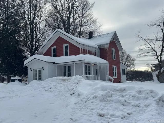 a view of a house with a yard covered in snow