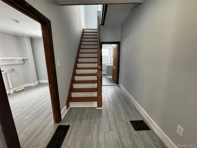 a view of a hallway with wooden floor and staircase