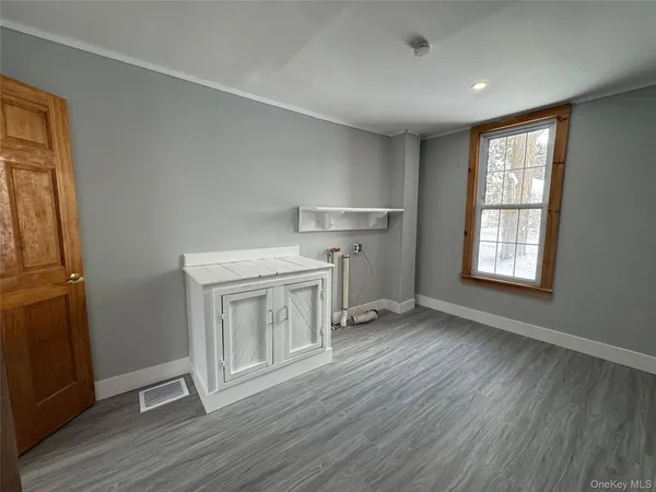 a view of an empty room with wooden floor
