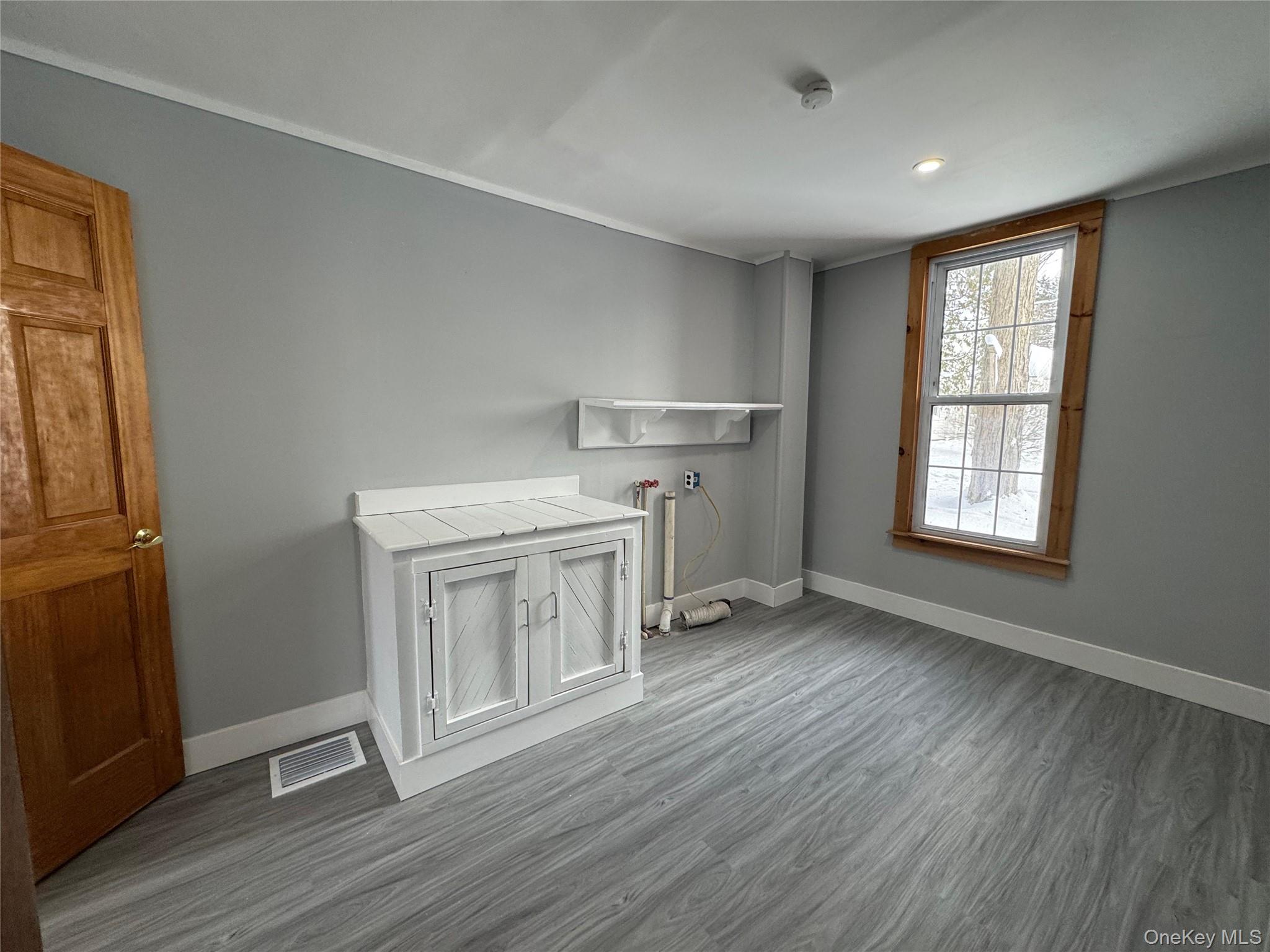 9606 Lincoln Avenue Remsen, NY 13438 - Photo 23 of 47 an empty room with wooden floor cabinet and windows