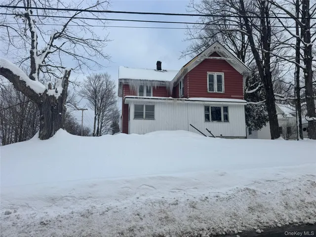 a front view of a house with a snow in the yard