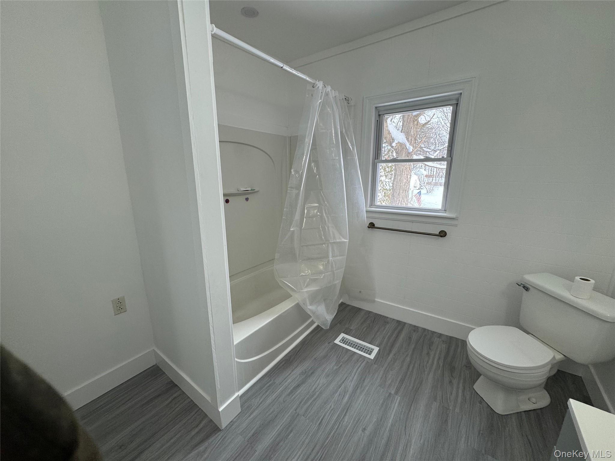 9606 Lincoln Avenue Remsen, NY 13438 - Photo 34 of 43 Bathroom featuring shower / bathtub combination with curtain, dark wood-style floors, and ornamental molding
