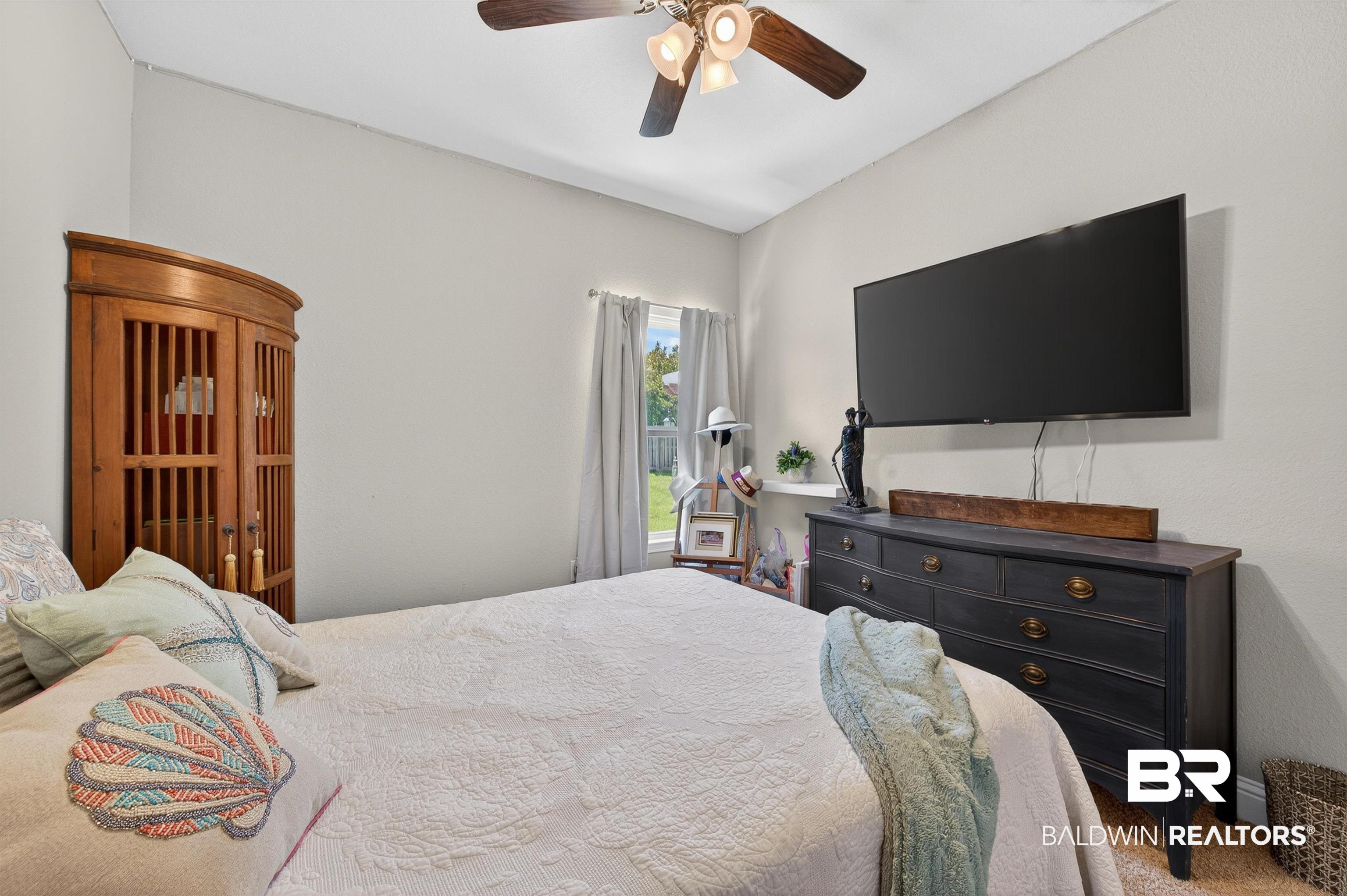 8735 Bronze Lane Foley, AL 36535 - Photo 34 of 58 Carpeted room featuring a ceiling fan with integrated lighting, a window with curtains, and light-colored walls