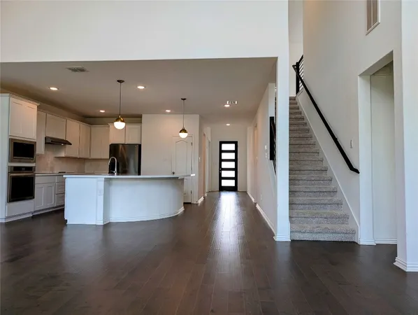 an open kitchen view with wooden floor and a sink