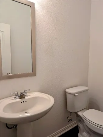 a bathroom with a sink a toilet and mirror