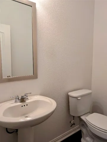 a bathroom with a sink a toilet and mirror