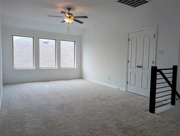 a view of empty room with ceiling fan