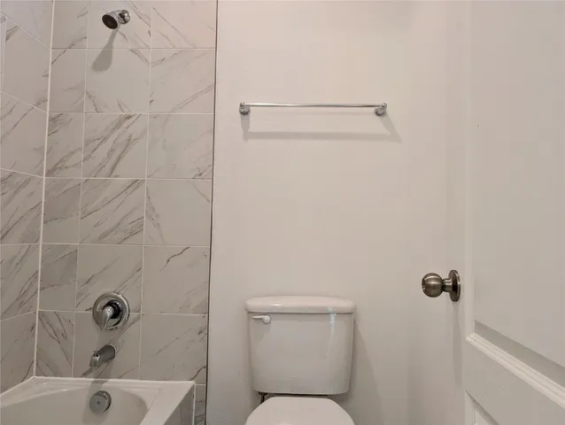 a bathroom with a toilet and shower