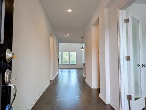 a view of a hallway with wooden floor