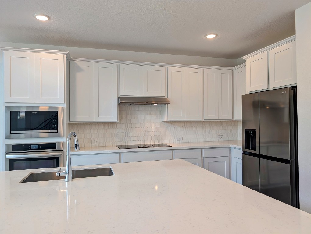 1344 Ridge Runner Drive Georgetown, TX 78628 - Photo 6 of 37 a kitchen with a refrigerator and a stove top oven