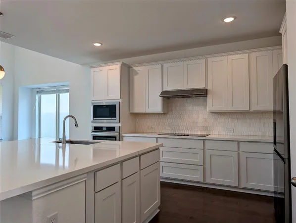 a kitchen with granite countertop white cabinets and sink