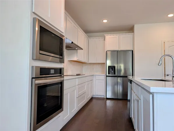 a kitchen with stainless steel appliances a stove a microwave and a refrigerator