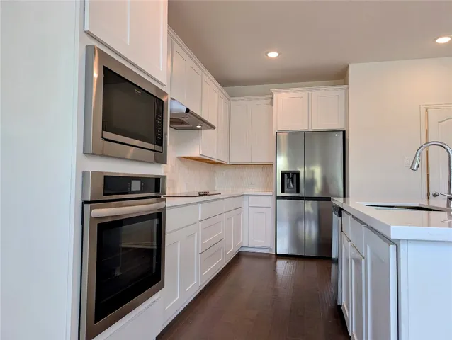 a kitchen with stainless steel appliances a stove a microwave and a refrigerator
