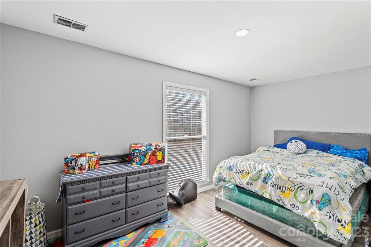 9099 Pitcairn Drive Tega Cay, SC 29708 - Photo 14 of 21 a bedroom with a bed and wooden floor
