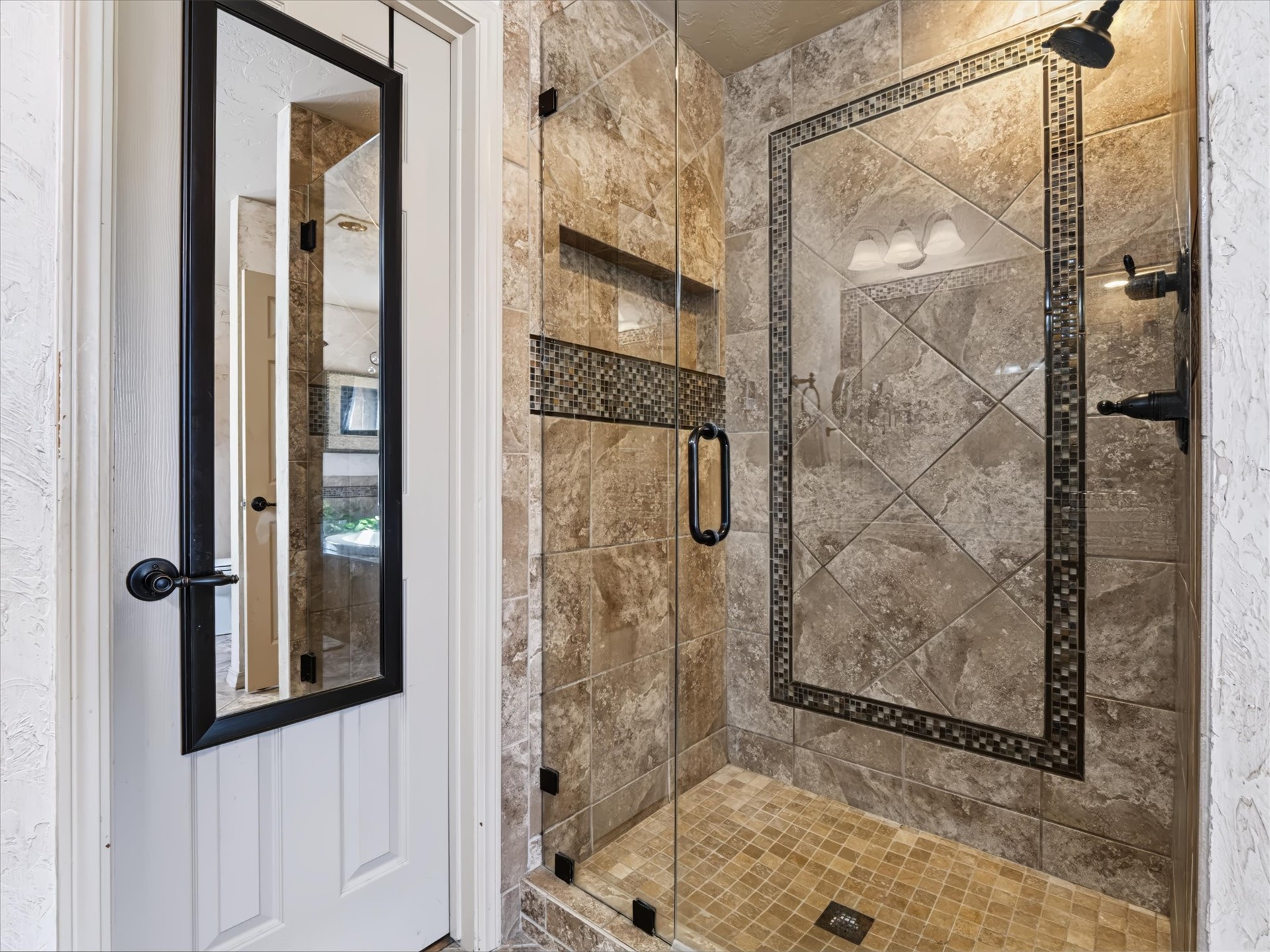 1133 West Chicken Fight Road Atoka, OK 74525 - Photo 17 of 49 Glass-enclosed shower with a mosaic tile accent band and patterned wall tiling