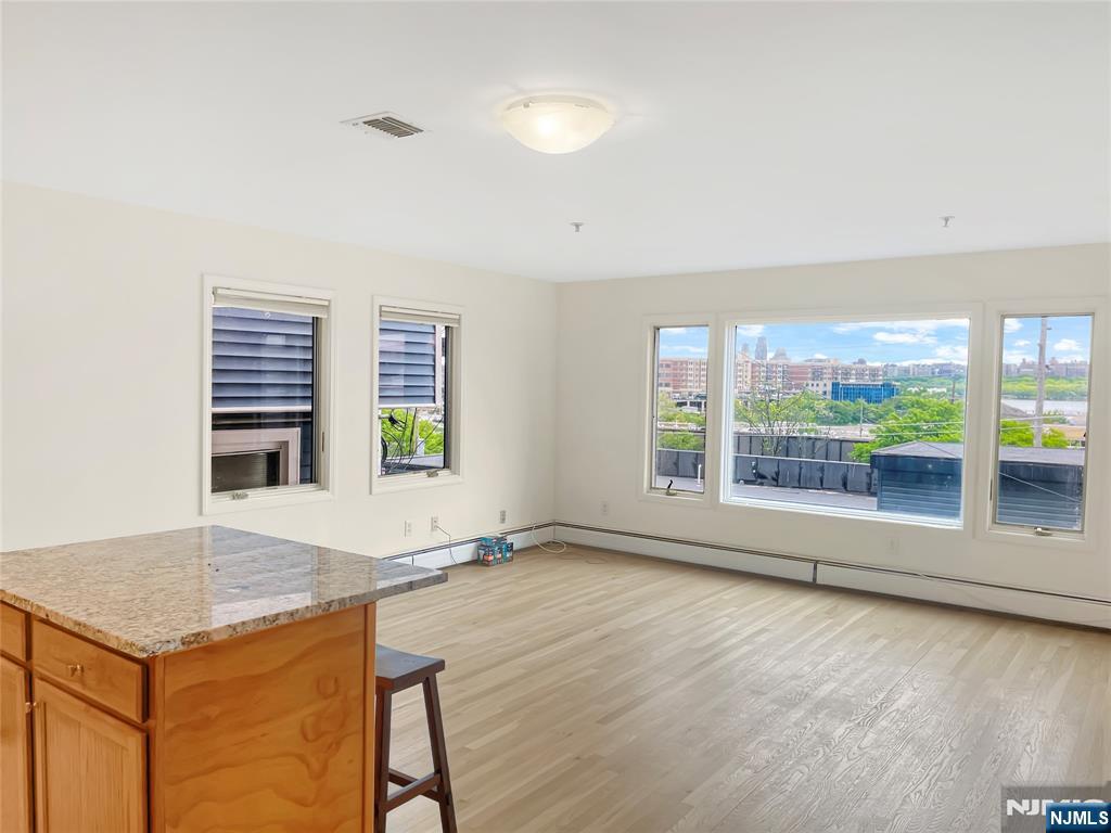 8913 Riverside Place, Unit 3 North Bergen, NJ 07047 - Photo 2 of 17 an empty room with a fireplace and large windows