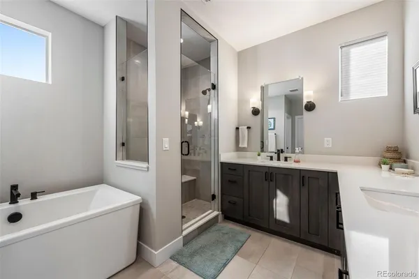 a spacious bathroom with a tub sink and mirror