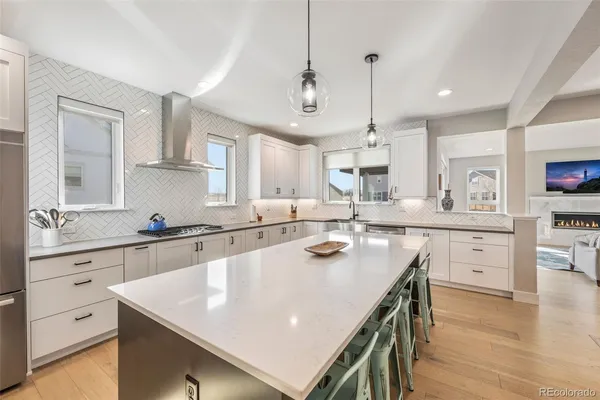 a kitchen with white cabinets appliances and wooden floor