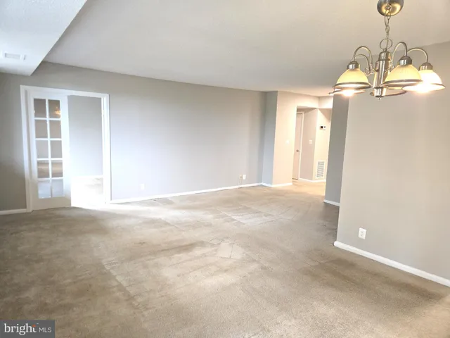 a living room with furniture a rug and white walls