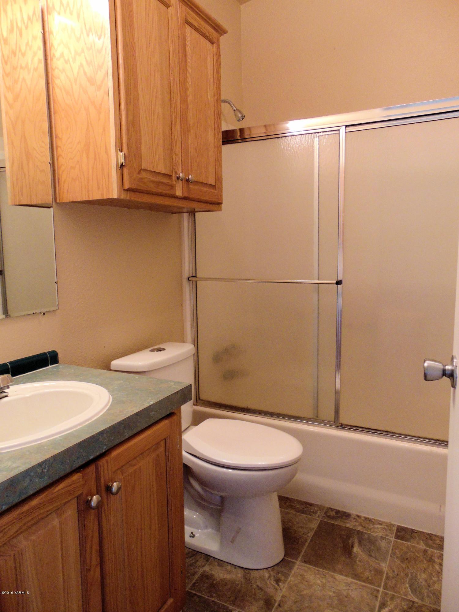 151 Cook Road Yakima, WA 98908 - Photo 12 of 13 a bathroom with a granite countertop toilet sink and mirror