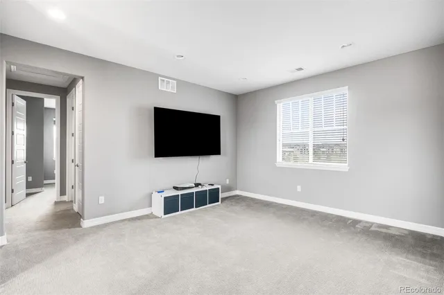 a living room with a flat screen tv and windows