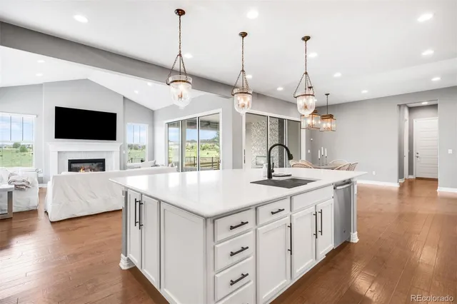 a kitchen with sink stove and wooden floor