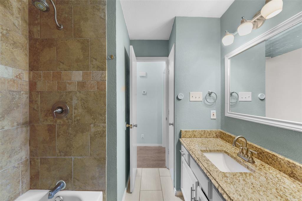 2127 Holt Road Arlington, TX 76006 - Photo 12 of 18 a bathroom with a granite countertop sink a mirror and shower