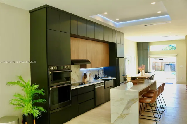 a kitchen with stainless steel appliances kitchen island granite countertop a table and chairs in it