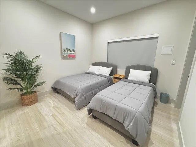 a bedroom with two beds and a potted plant