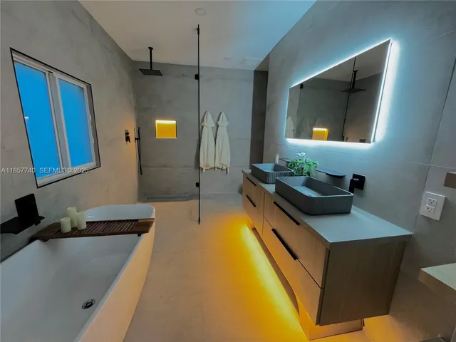 a bathroom with a tub a double vanity sink and mirror