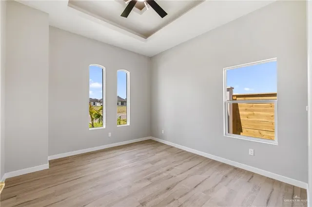 an empty room with window and wooden floor