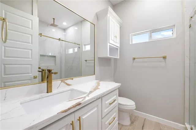 a bathroom with a granite countertop sink toilet and shower