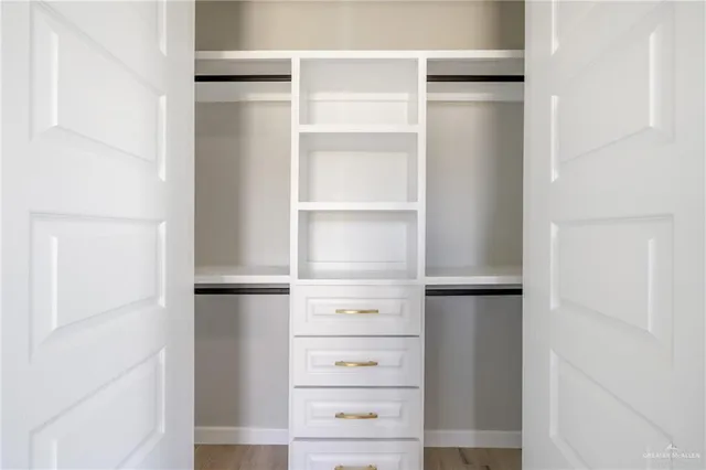 a view of walk in closet with empty racks