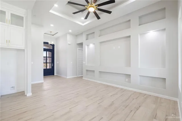 a view of an empty room with cabinet and a ceiling fan