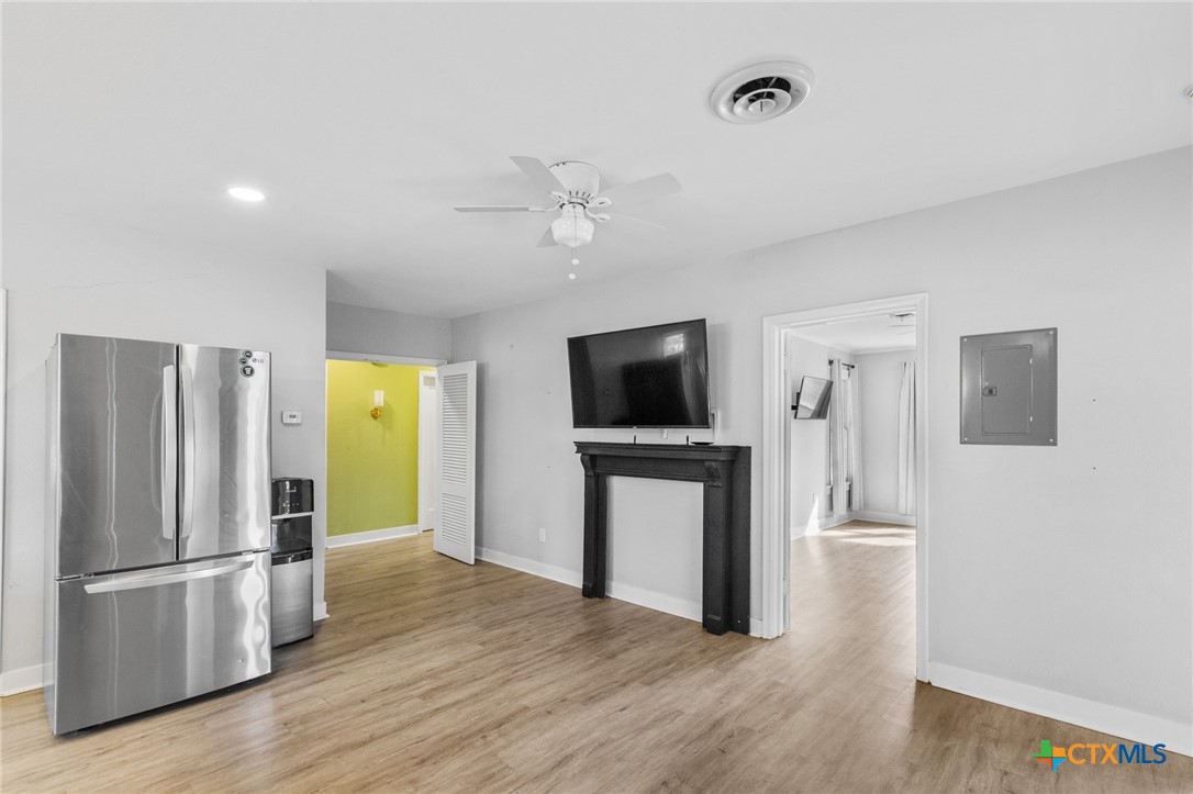 3109 North Main Street Victoria, TX 77901 - Photo 12 of 29 a view of a livingroom with a flat screen tv wooden floor and a refrigerator