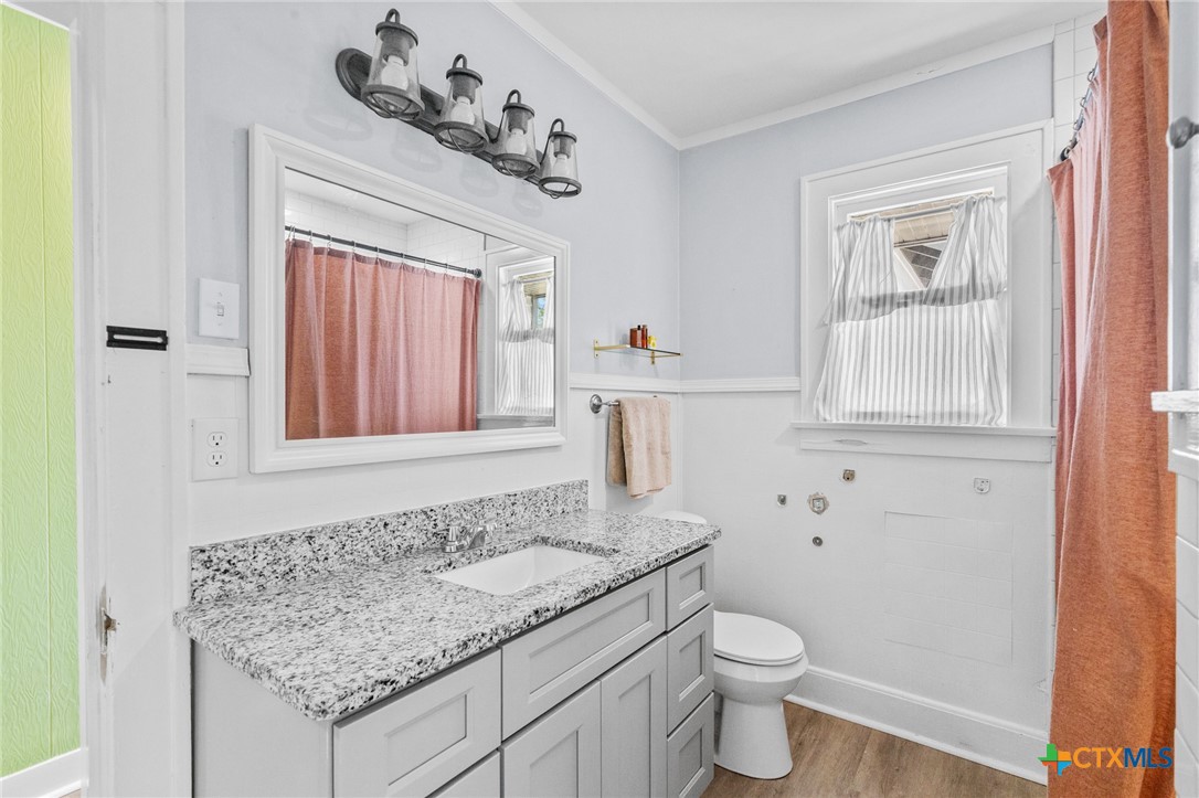 3109 North Main Street Victoria, TX 77901 - Photo 18 of 29 a bathroom with a granite countertop sink and a toilet