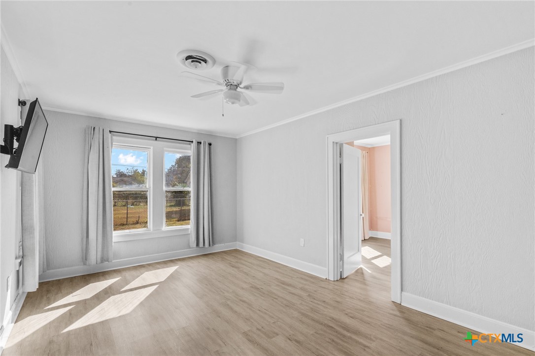 3109 North Main Street Victoria, TX 77901 - Photo 19 of 29 an empty room with wooden floor and windows