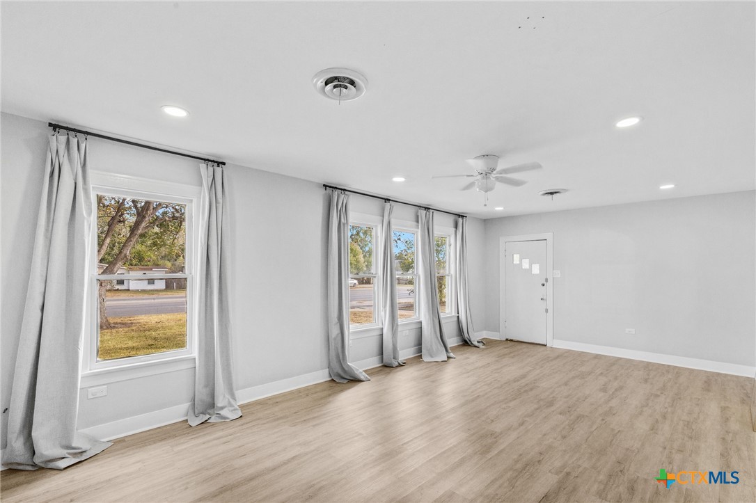 3109 North Main Street Victoria, TX 77901 - Photo 21 of 29 wooden floor in an empty room with a window